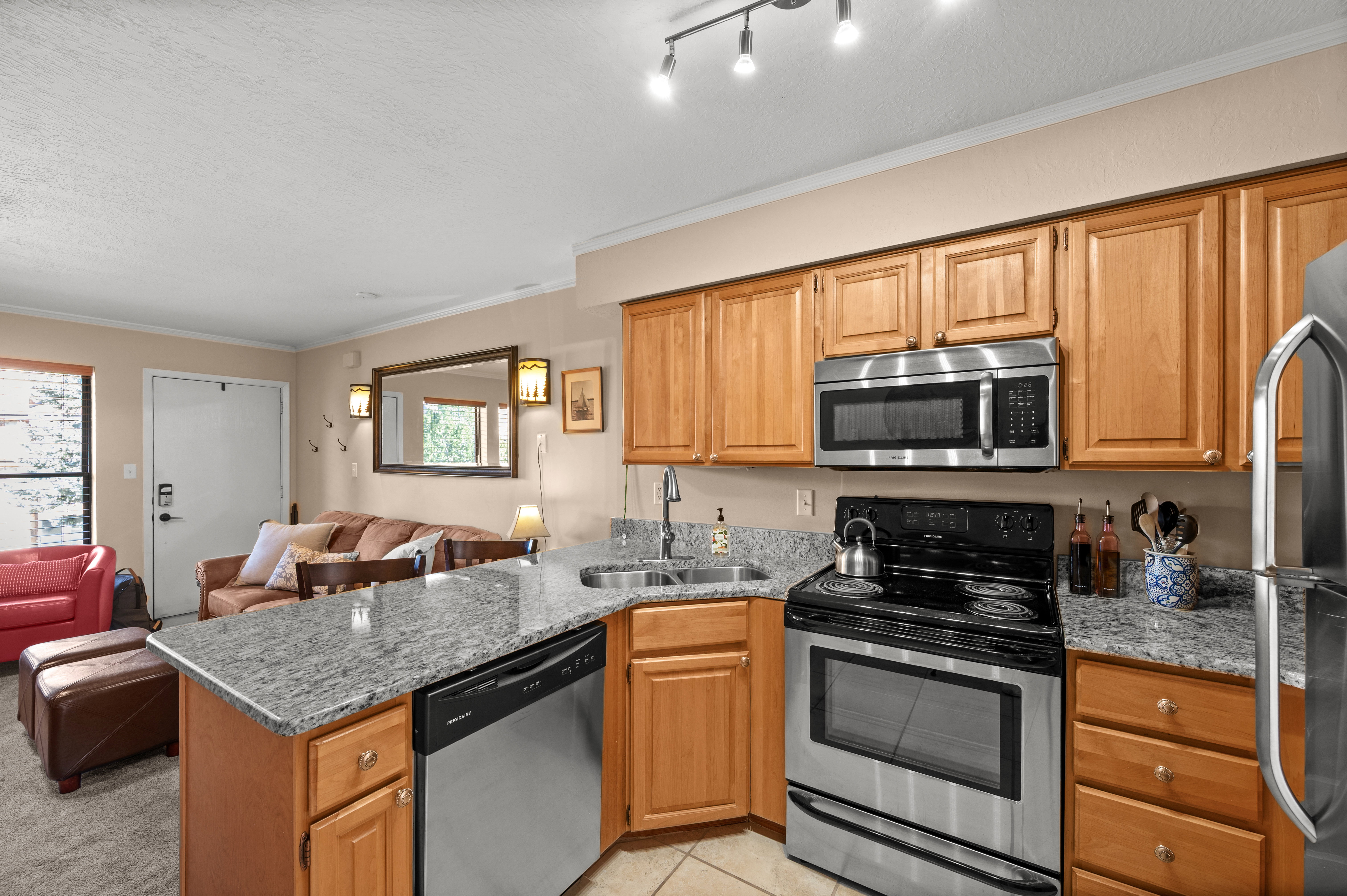 Kitchen with stainless steel appliances, a peninsula, open floor plan, healthy amount of natural light, and crown molding