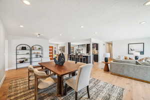 Dining room with light wood finished floors and recessed lighting