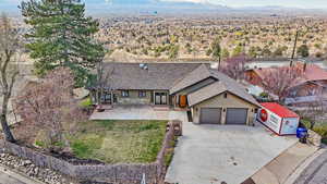 View of front of house with concrete driveway, an attached garage, a shingled roof, stucco siding, and a mountain view