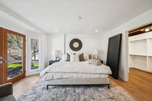 Bedroom featuring a spacious closet, access to exterior, light wood-style floors, and recessed lighting
