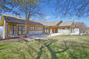 Rear view of house featuring a shingled roof and brick siding