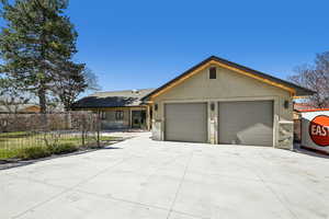 Single story home featuring an attached garage, stucco siding, concrete driveway, and stone siding