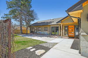 Entrance to property featuring french doors, a shingled roof, stucco siding, and stone siding