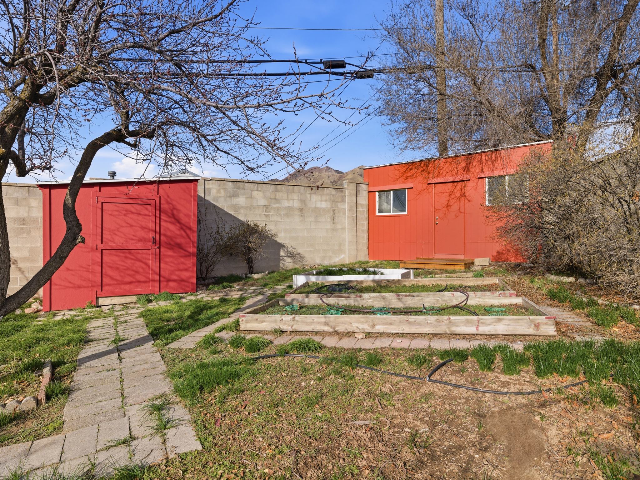 Fenced yard featuring a storage unit and a garden