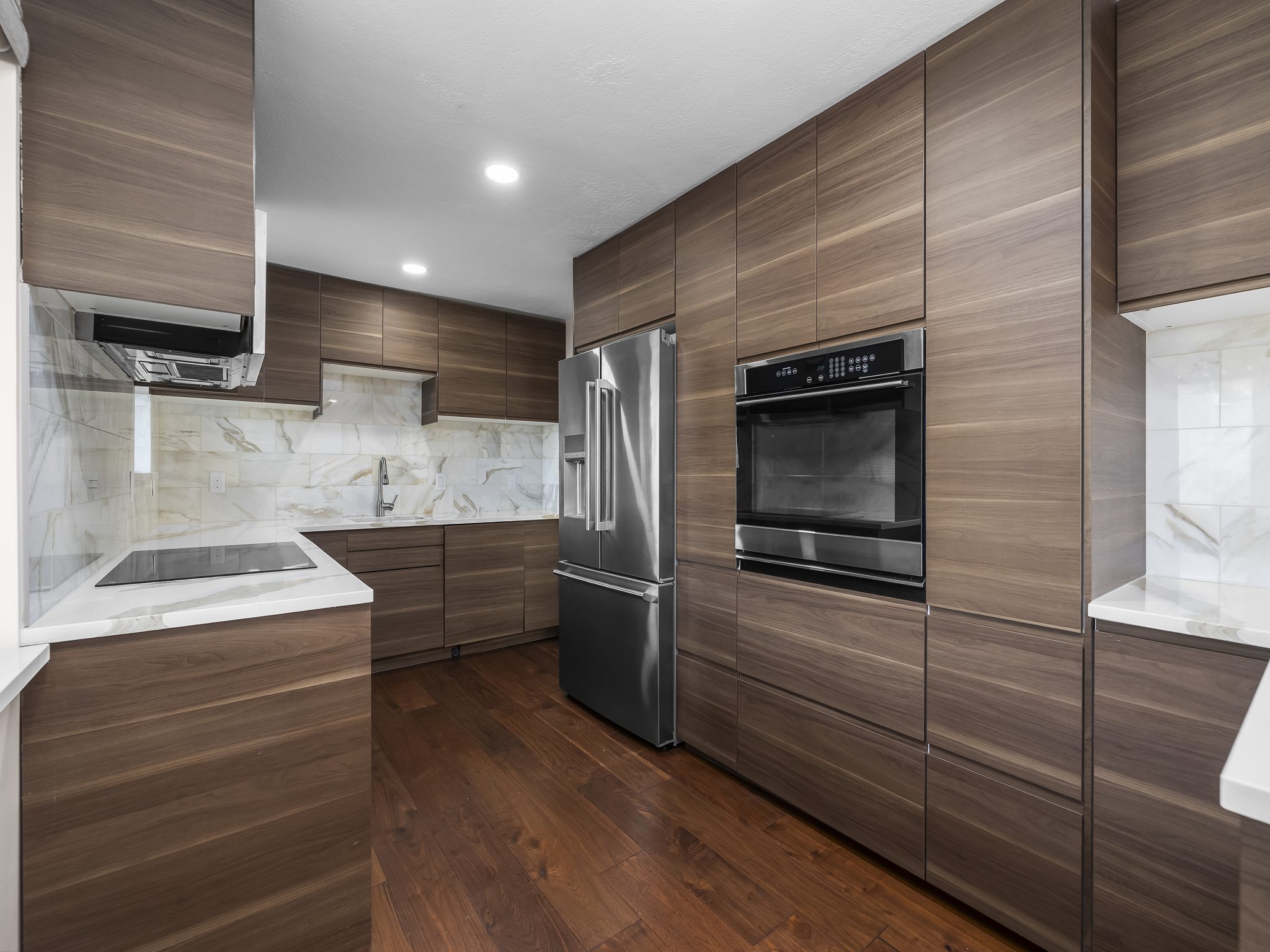 Kitchen featuring modern cabinets, light stone counters, oven, and recessed lighting
