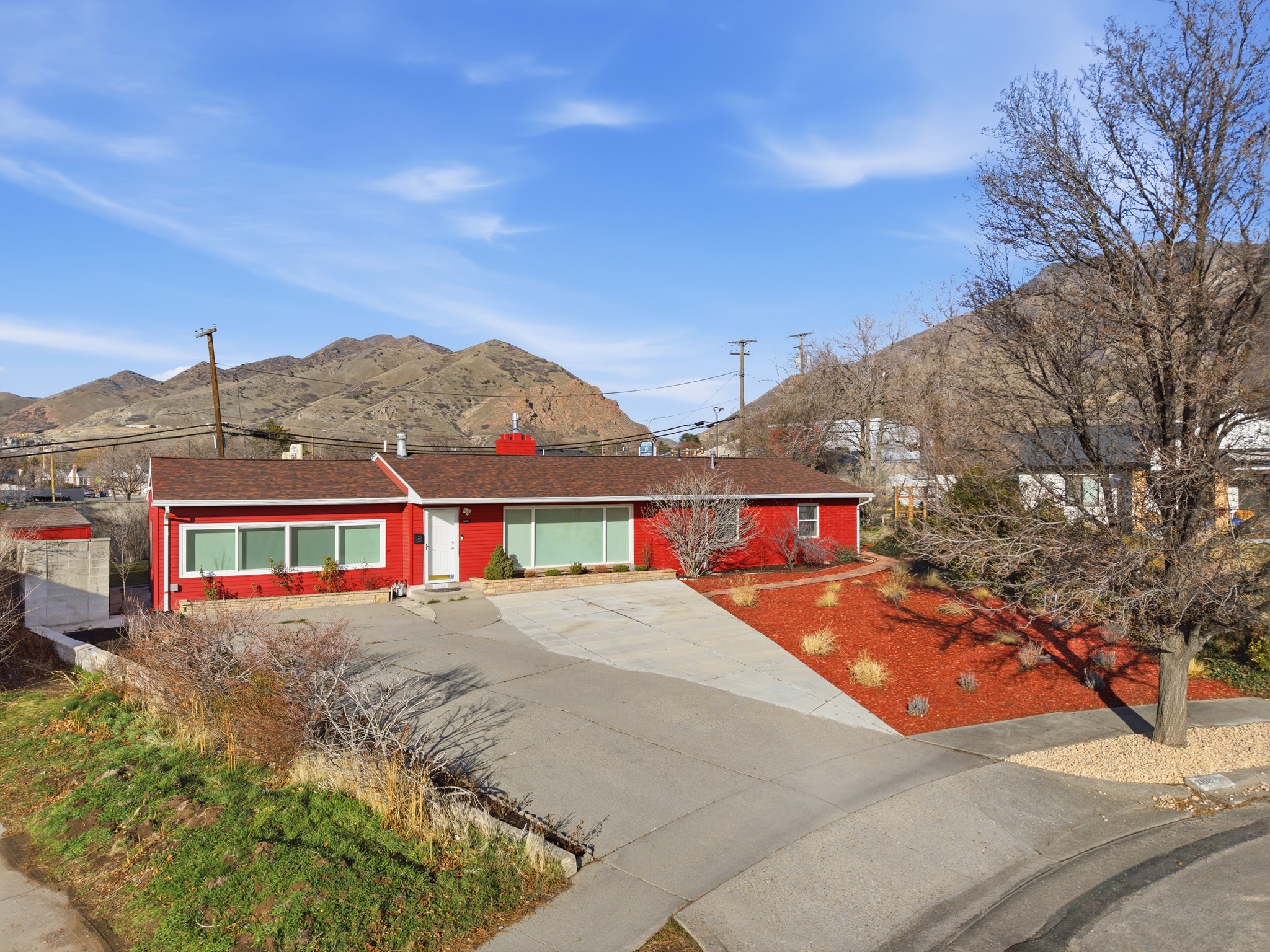 Ranch-style house featuring a mountain view, a shingled roof, brick siding, and driveway