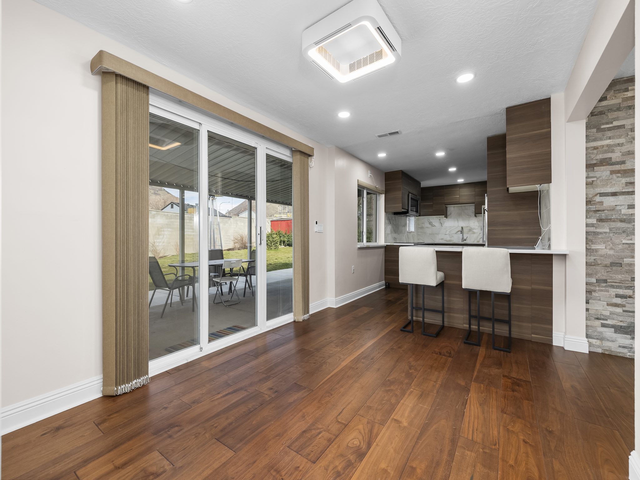 Kitchen featuring a breakfast bar area, a peninsula, dark wood-style floors, modern cabinets, and recessed lighting