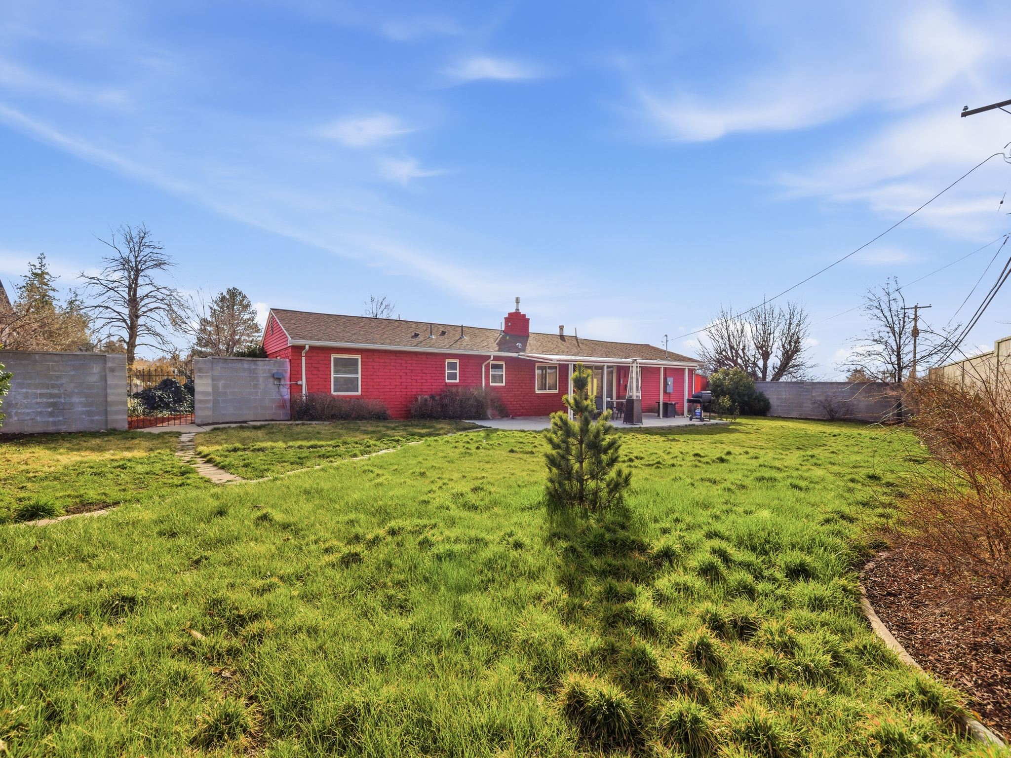 Rear view of property with a fenced backyard, brick siding, a chimney, and a patio area