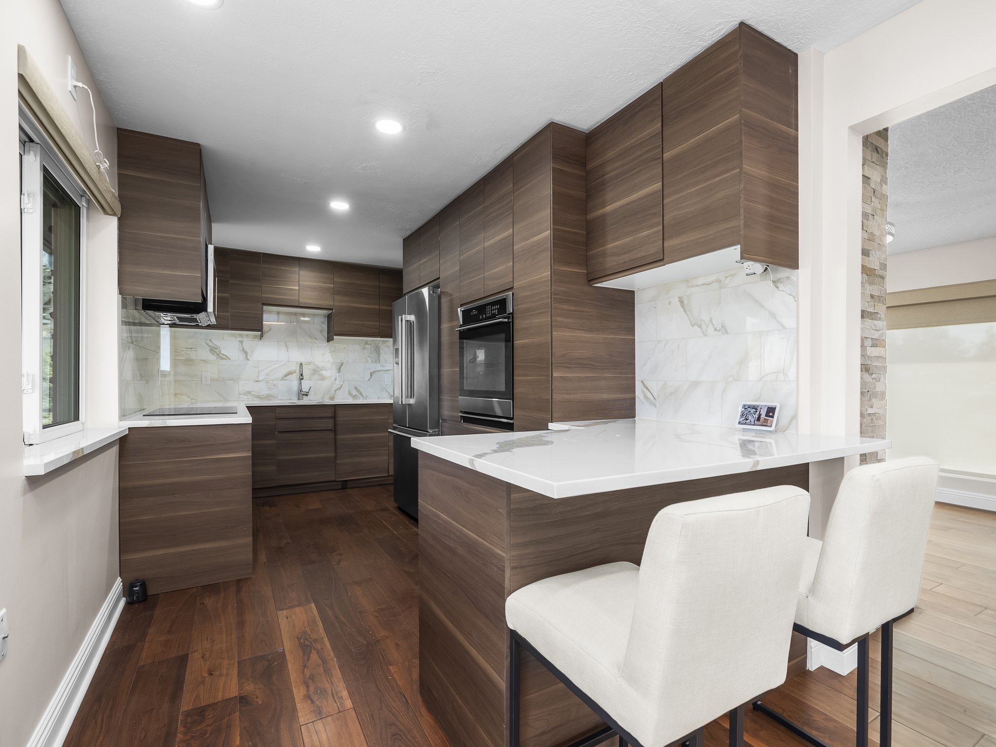 Kitchen featuring plenty of natural light, a kitchen breakfast bar, modern cabinets, and a peninsula