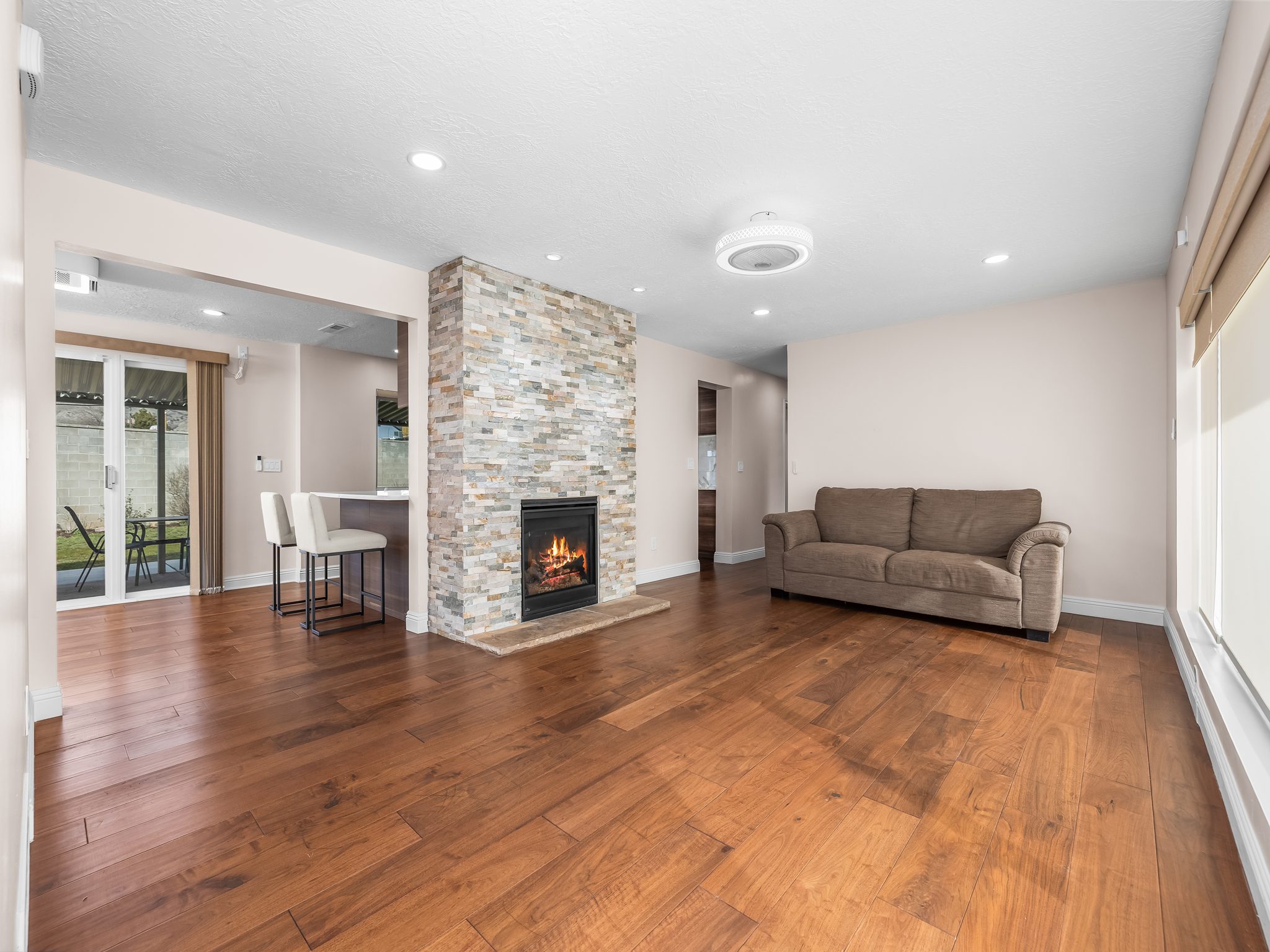 Living area featuring hardwood / wood-style floors, a stone fireplace, and recessed lighting