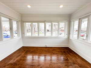 Unfurnished sunroom with hardwood / wood-style floors and recessed lighting
