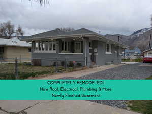 View of front of house with a gate, a fenced front yard, a mountain view, and a porch