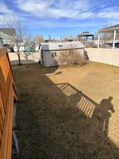Fenced backyard with an outdoor structure and a gazebo