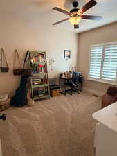 Home office with light colored carpet and a ceiling fan