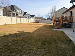 Fenced backyard featuring a wooden deck and a residential view