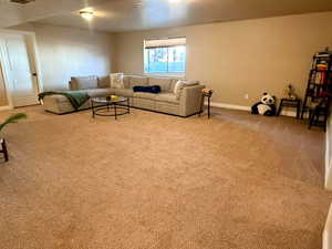 Carpeted living area featuring baseboards