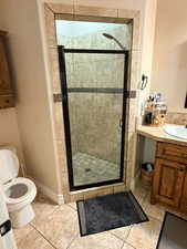 Bathroom with vanity, a stall shower, and light tile patterned floors