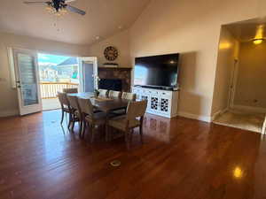Dining room featuring dark wood-type flooring, vaulted ceiling, and a ceiling fan