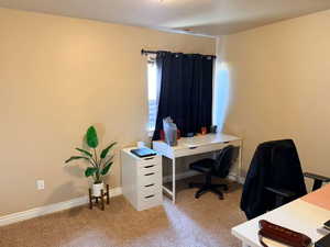 Office area featuring light carpet and baseboards