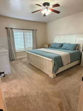 Bedroom with carpet, a ceiling fan, and a textured ceiling