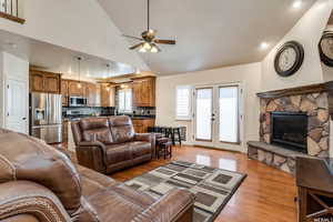 Living room with light wood-style floors, vaulted ceiling, ceiling fan, french doors, and recessed lighting