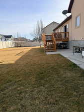 Fenced yard featuring a wooden deck and stairway