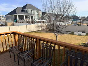 Wooden deck with a residential view, a garden, and a fenced backyard