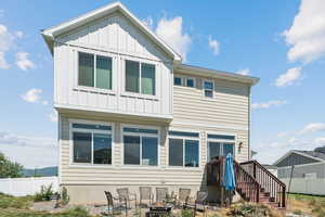 Rear view of property with board and batten siding and an outdoor fire pit