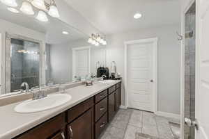 Bathroom with a shower stall, double vanity, light tile patterned flooring, and recessed lighting
