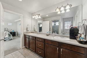 Ensuite bathroom with double vanity, light carpet, light tile patterned flooring, a shower stall, and recessed lighting