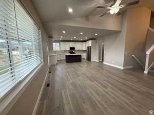 Unfurnished living room featuring recessed lighting, dark wood-type flooring, ceiling fan, and lofted ceiling