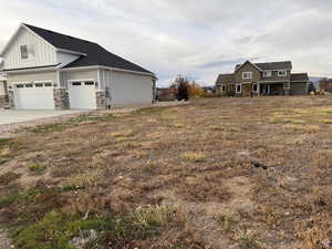 View of yard with driveway and a porch