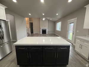Kitchen featuring freestanding refrigerator, a ceiling fan, dual tone cabinets, recessed lighting, and a premium fireplace