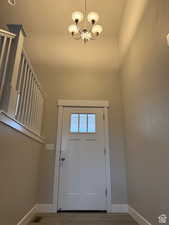 Doorway featuring hanging lights and wood finished floors