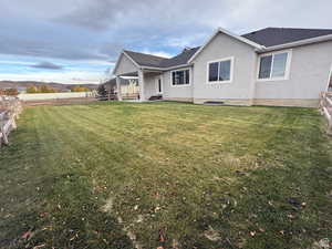 Rear view of property featuring a fenced backyard, stucco siding, a patio area, and a shingled roof