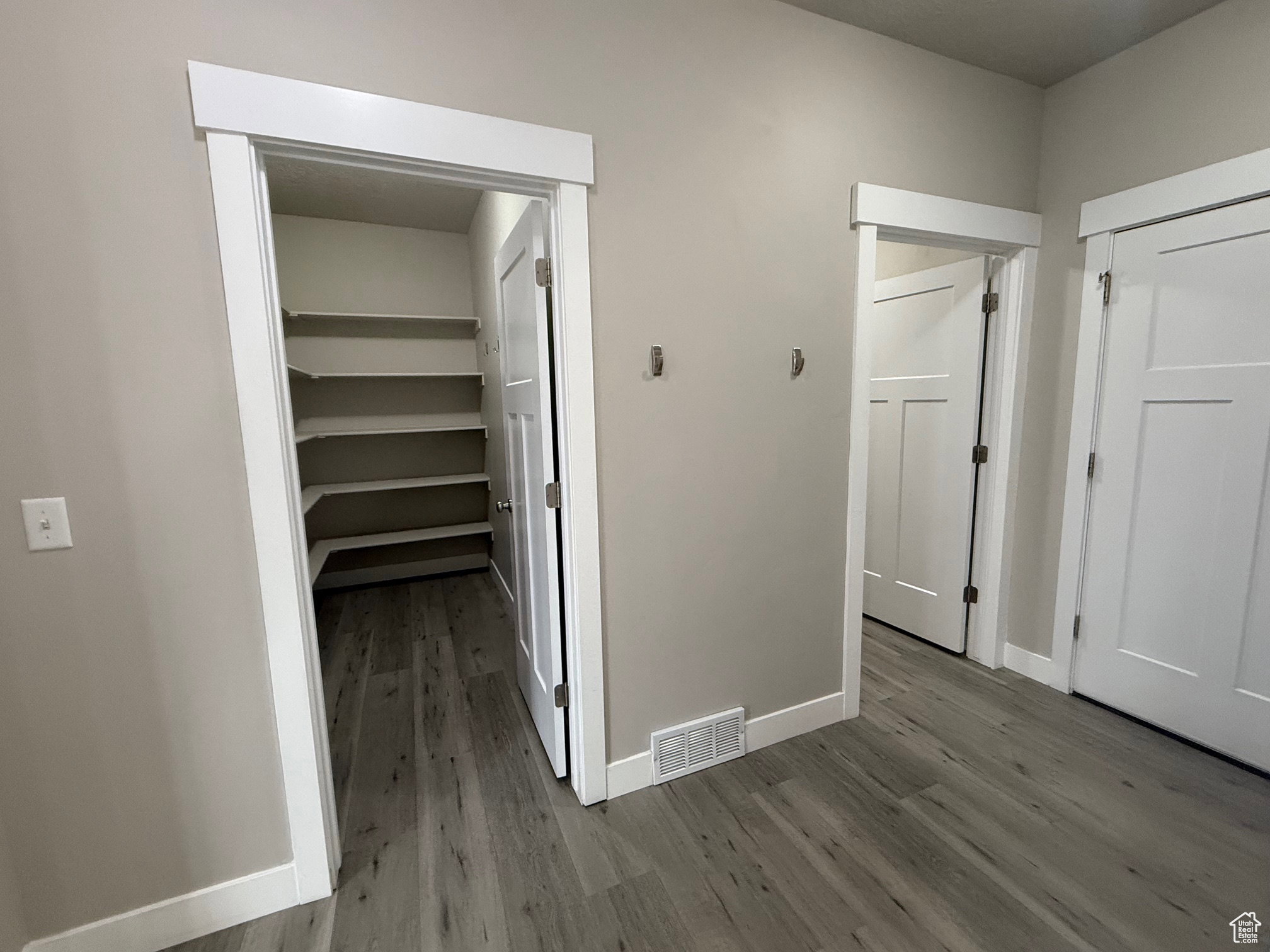 Hallway with dark wood-style floors and baseboards