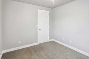 Carpeted empty room featuring baseboards