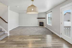 Unfurnished living room with a tile fireplace, light wood-style floors, and a textured ceiling