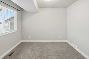 Carpeted empty room featuring a textured ceiling