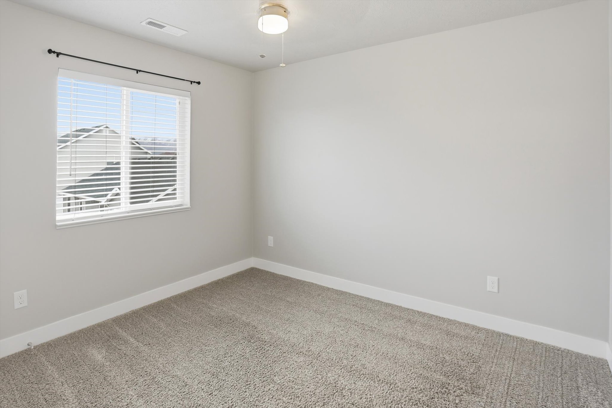 Unfurnished room featuring light carpet and baseboards