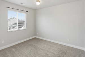 Unfurnished room featuring light carpet and baseboards