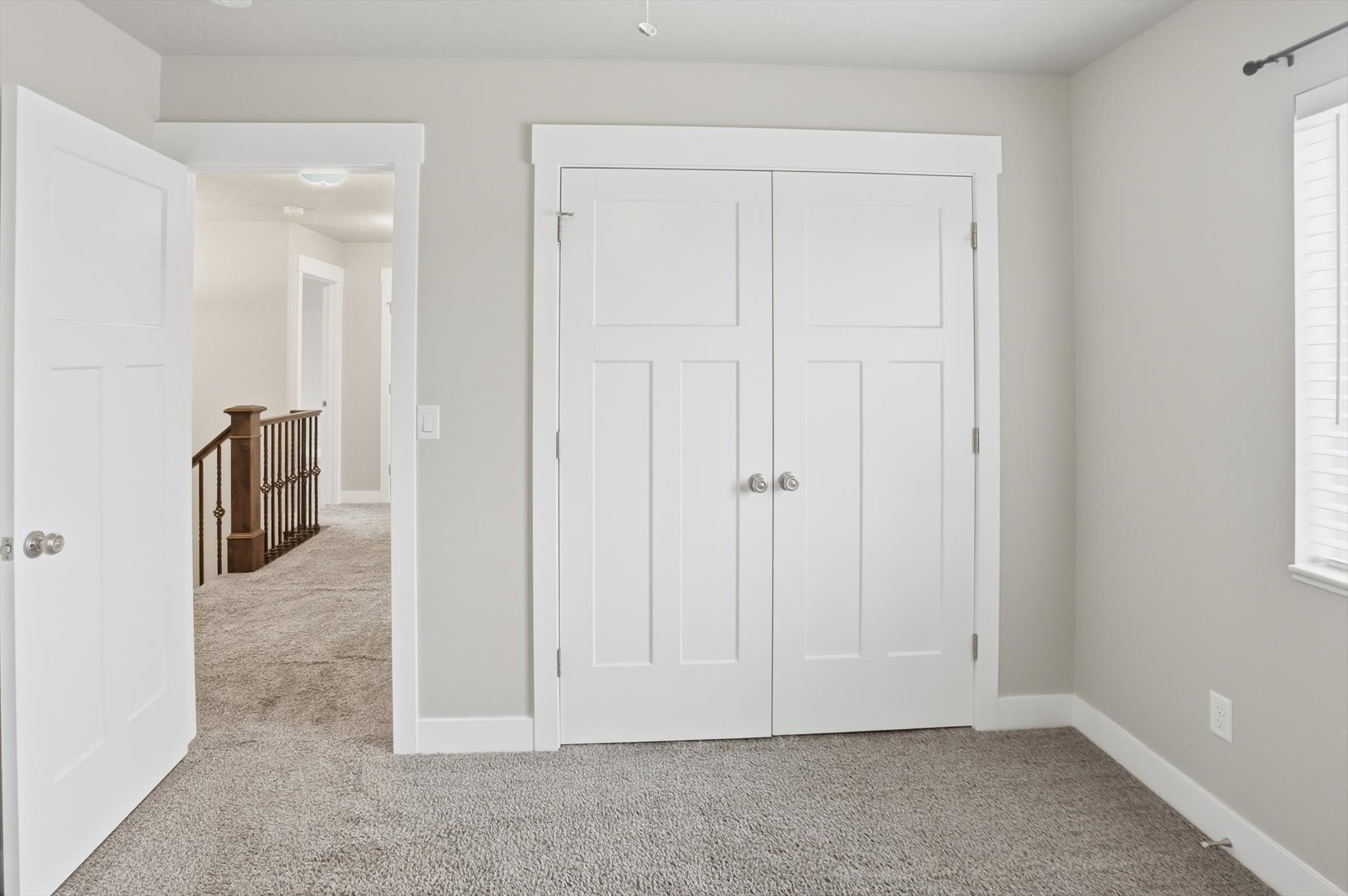 Unfurnished bedroom with light colored carpet and a closet