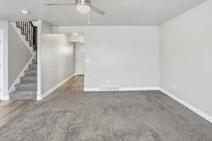 Spare room with ceiling fan, light colored carpet, and a textured ceiling