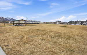 View of grassy yard featuring a patio area and a mountain view