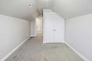 Additional living space featuring light carpet and a textured ceiling