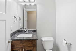 Half bathroom featuring vanity and toilet