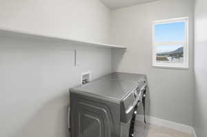 Laundry room featuring washing machine and dryer and baseboards