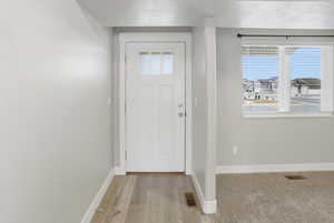 Entryway with a textured ceiling and light wood-style floors