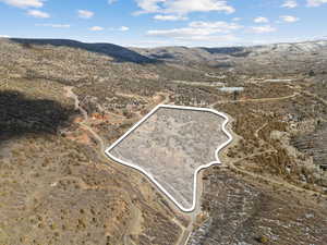 Overview of rural landscape featuring a mountainous background and property boundaries highlighted