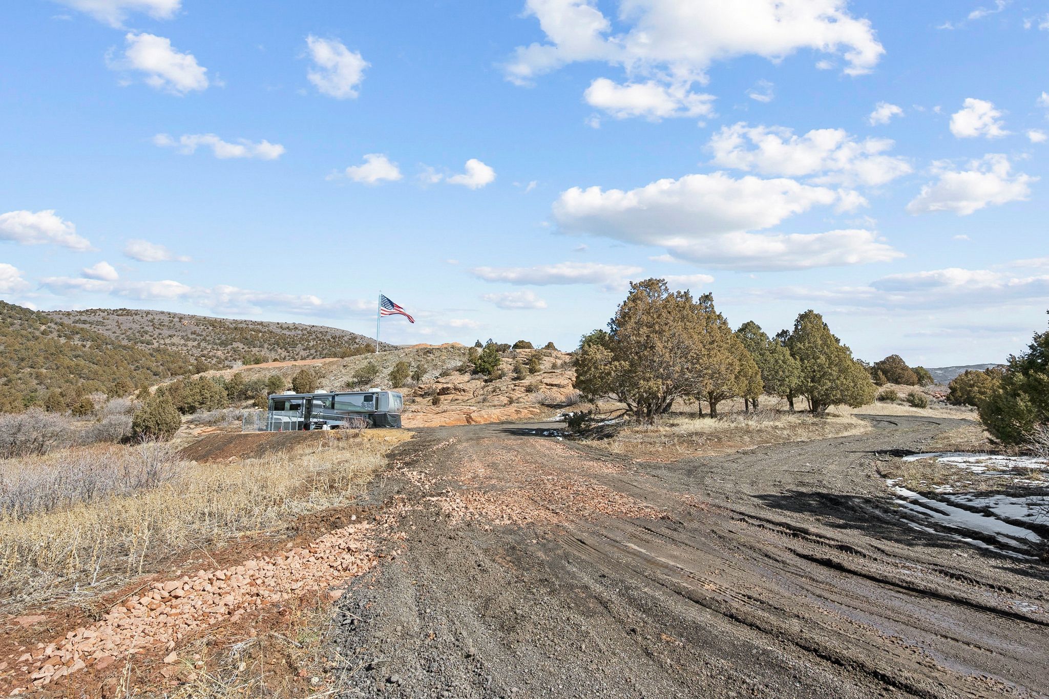 View of dirt / gravel road with a view of countryside and a mountain view